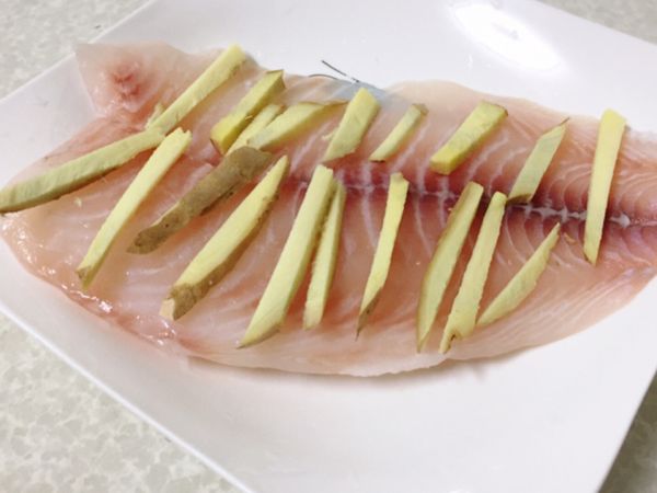 把切絲的乾薑均勻的鋪在鯛魚身上，要均勻，才會除腥味！