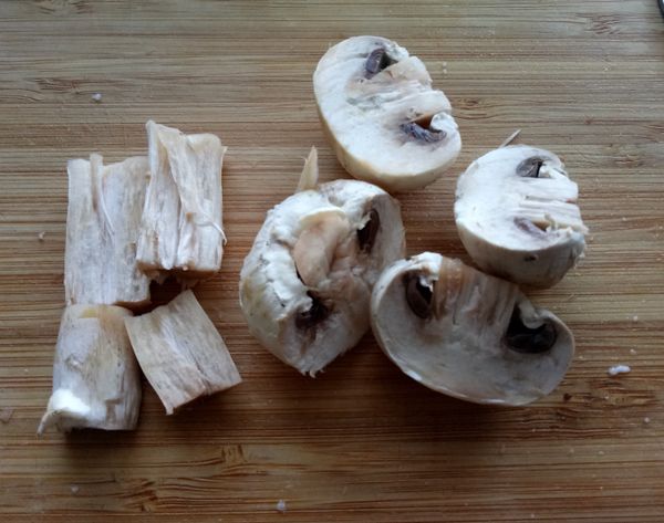 將洋菇切分為其傘身與蒂頭，並各切為1/2大小。