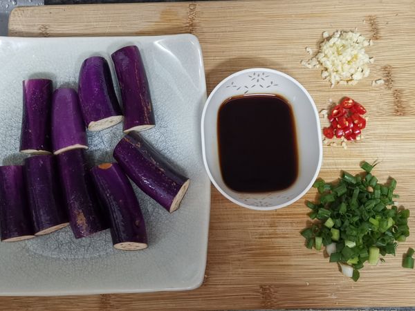 茄子去頭去尾洗淨切成段後，泡入鹽水中備用；醬汁所有材料調勻；
蒜頭切末；辣椒和蔥切細粒。