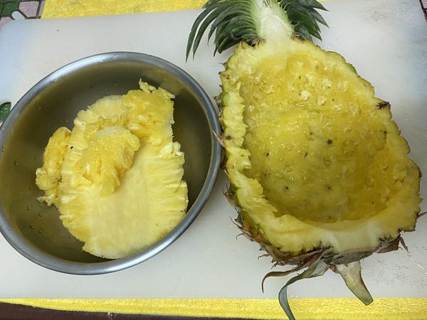 鳳梨剖半並取出鳳梨肉，將鳳梨肉切小塊，一會兒要和蝦一起炒。而鳳梨殼就當做盤子用，環保又健康。