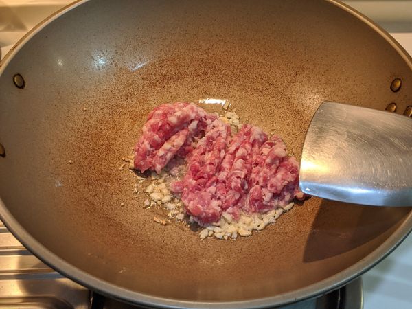 加入絞肉拌炒到肉全部變色( 炒到沒有紅色)，再加米酒拌炒一下去腥味