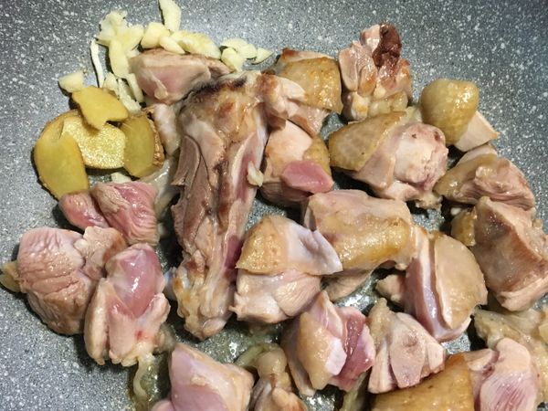 雞腿肉翻面後就可放入大蒜和薑片一起翻炒⋯