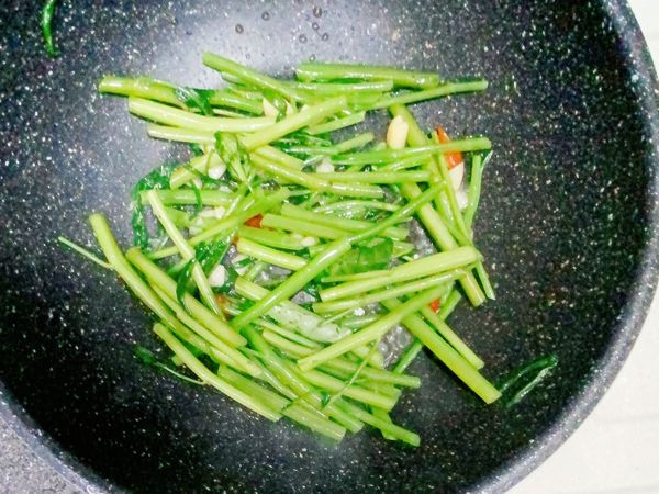 起油鍋，爆香大蒜、辣椒，先倒入空心菜頭炒一下