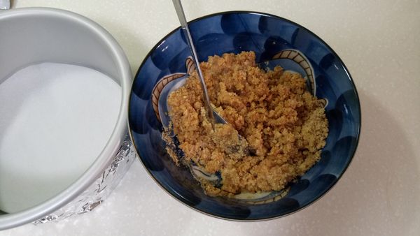 敲碎的消化餅乾放入融化的奶油裡面，攪拌均勻。