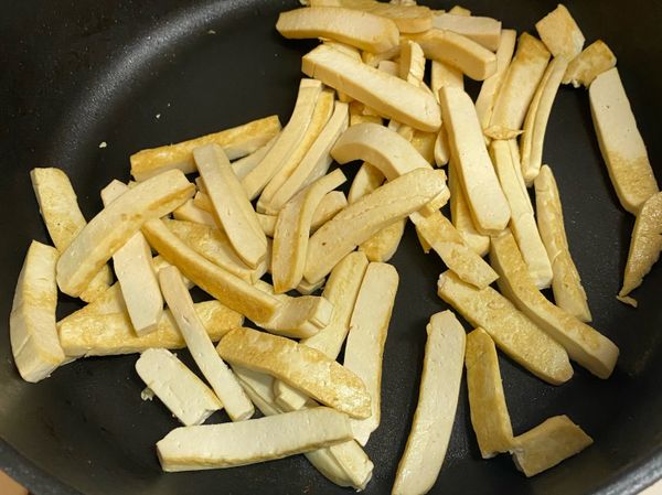 芹菜切段、紅蘿蔔切絲、蒜頭切末。肉絲加入醬油、白胡椒粉、香油醃30分鐘以上備用。

豆乾切片，中小火煎約10分鐘，煎至兩面金黃起鍋備用。