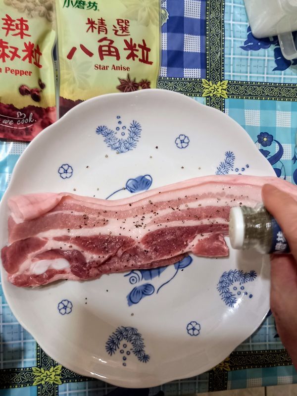 豬五花均勻塗抹鹽巴，再灑上黑胡椒粒