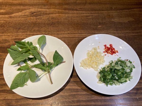 先將青蔥切成蔥花、辣椒切成小圈、蒜切成蒜碎與蒜片、九層塔剝成一片一片。