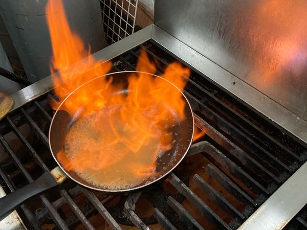 轉大火加入米酒焰燒煮開，加入蛤蠣高湯後煮滾後加入胡椒鹽調味、下蛤蠣、九層塔再次滾後起鍋。