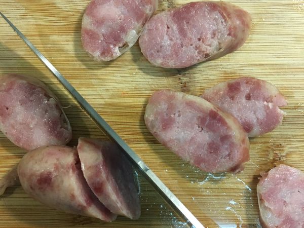 首先將香腸以滾水燙約15分鐘燙熟後，撈出放涼後切成片狀備用