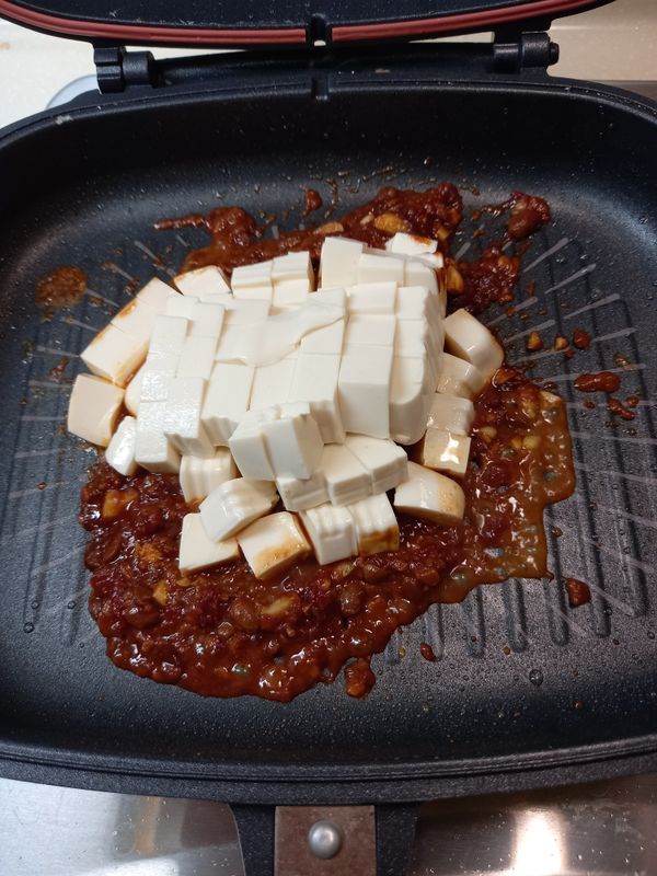 放入豆腐加兩碗半（飯碗）的水，燒至豆腐入味