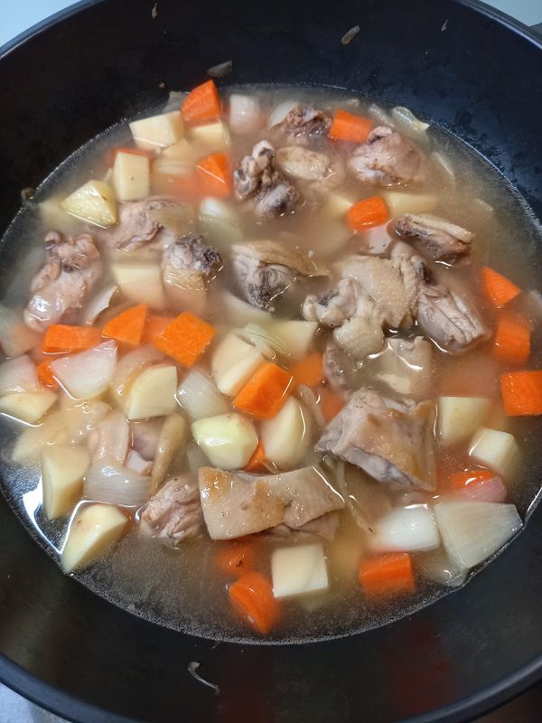 接著放入紅蘿蔔和馬鈴薯， 並加入水淹過食材，蓋上鍋蓋煮15分鐘