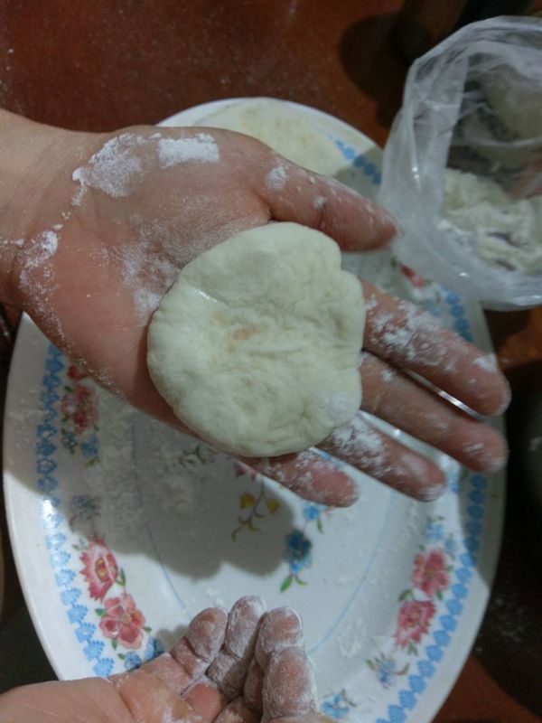 手沾一點麵後會比較好，抓一小糰出來，稍稍壓扁它就放著。