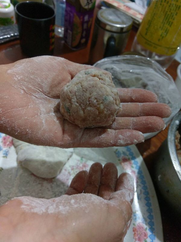 手抓一大糰肉餡，外面輕輕拍上一層麵粉，一邊成圓形。