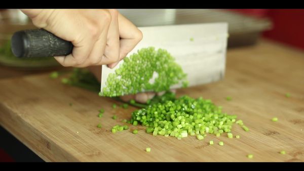 韭菜切成 0.2 公分，拌入香油，避免跟肉餡鹽份接觸後出水