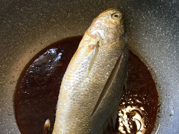 放入黃魚,再加半米杯清水,轉中火蓋上鍋蓋煮滾醬汁.....