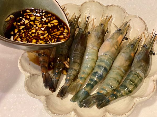 將調好的蒜醬淋在蝦子上。