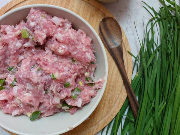 絞肉加入一匙鹽巴，順時針攪拌至有黏性，接著倒入香油、醬油、白胡椒粉、蔥，拌勻後將水（高湯）分次加入絞肉，持續攪拌至水分吃進去