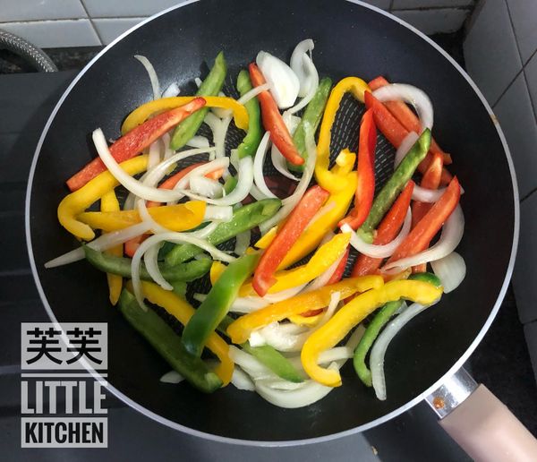 煎鍋上熱油，倒入洋蔥炒軟後，倒入三色椒炒一會。
