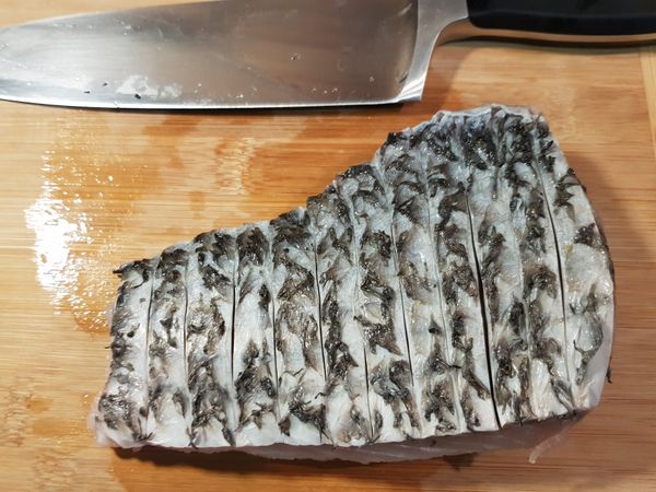在鱸魚魚皮劃上刀紋。
