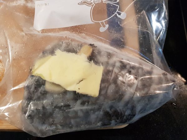 將鱸魚排和奶油、薑片一起放入夾鏈袋中，用少許鹽初步調味。
