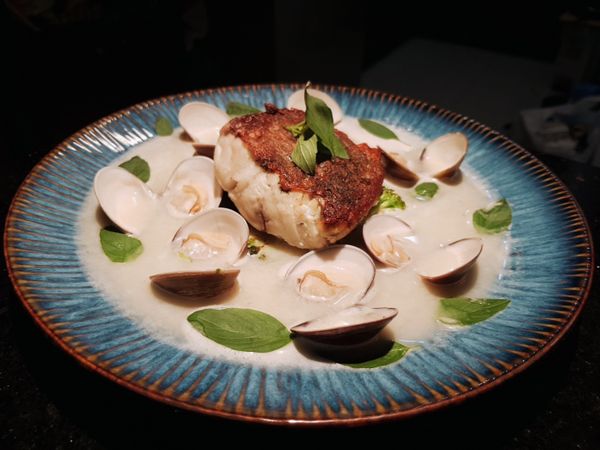 將大蒜蛤蜊高湯倒入盤子中，再用九層塔葉子裝飾，這道菜就完成啦！