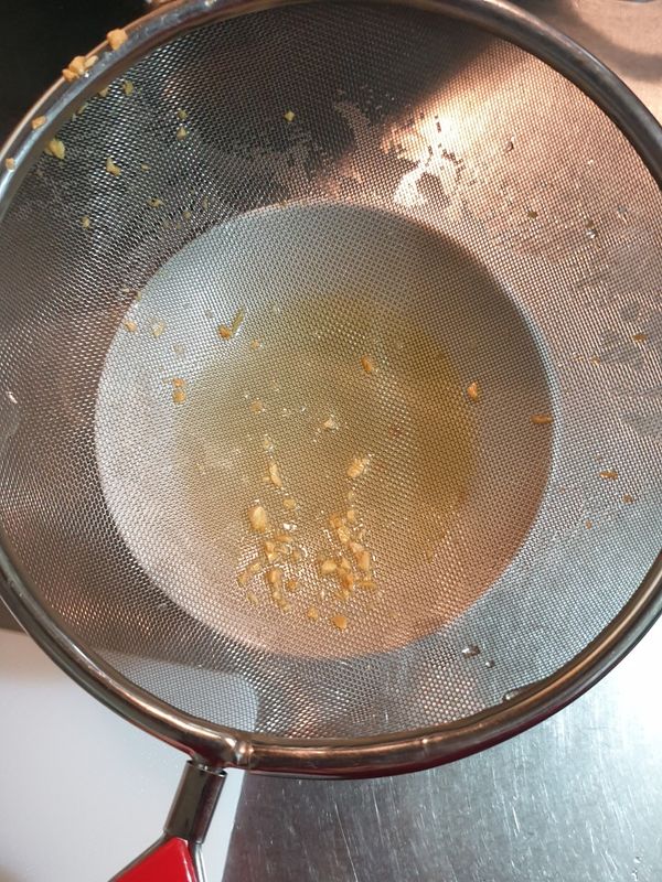 把蒜油透過濾網倒入碗中