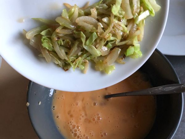 先將高麗菜絲、洋蔥絲、蒜頭、馬鈴薯絲炒香，然後加入蛋液裡攪拌均勻
（如果是香菇、蟹肉絲與洋蔥絲，一樣先翻炒後再加入蛋液喔）