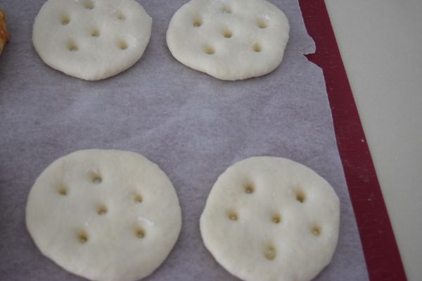 麵團發酵完畢後，將空氣壓出，分成4等份，醒置10分鐘。再將麵團壓扁，用手戳出六個孔洞。於室溫發酵50分鐘。