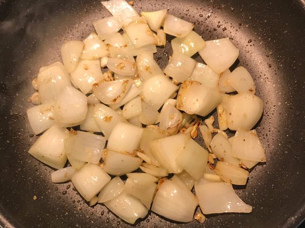 原鍋剩油將洋蔥與蒜片炒香；