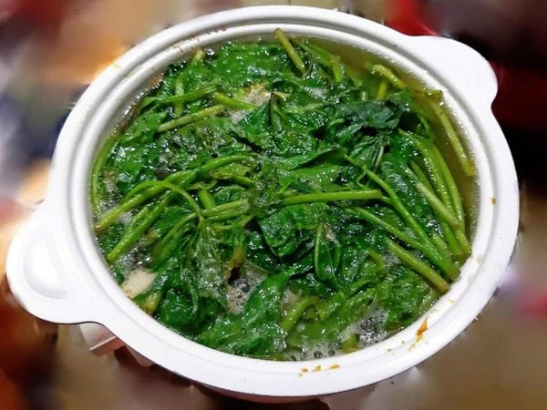 鍋中放水，加鹽和油，水燒開後下整理好的菜葉和菜梗。