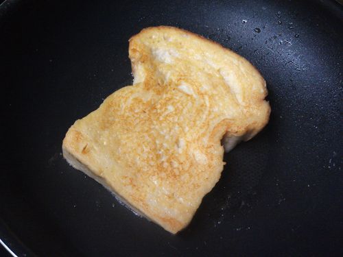 隔日，將平底鍋放入少許無鹽奶油加熱融化後，放入沾滿蛋奶液的白吐司，用小火慢煎至吐司兩面變成金黃色後，離火，灑上糖粉與喜歡的水果即可完成。