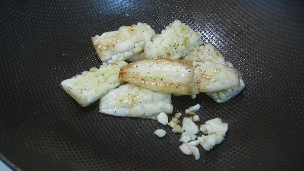 二面都煎至金黃色後，利用鍋內的餘油來爆香蒜頭末。（約1分鐘）