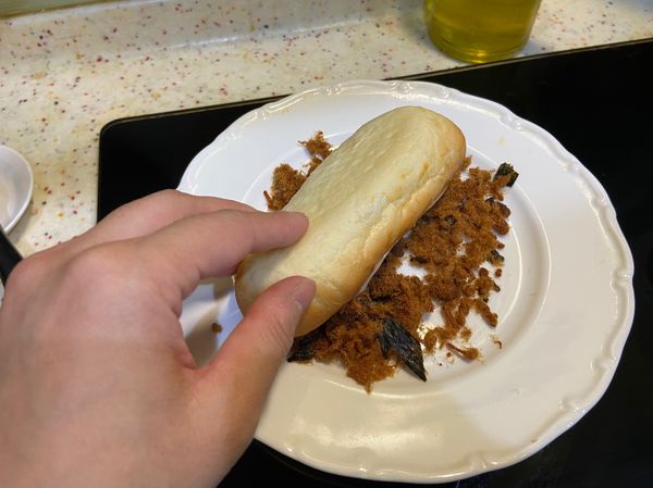 肉鬆放入盤子中預備，像途中這樣沾黏肉鬆，或是用手抓肉鬆讓它可以黏在麵包上。