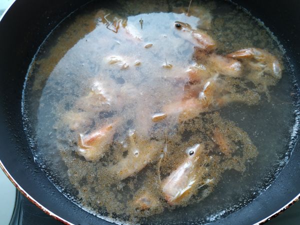 炒到聞到蝦子香味，沖入600cc的水，再加入少許米酒，煮滾後熄火瀝出，就是蝦湯鍋底