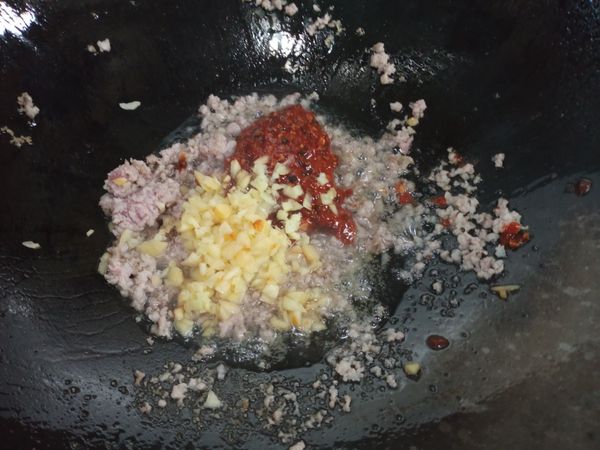 炒好後加入豆瓣醬及蒜末薑末繼續炒香
炒至豆瓣醬呈暗紅色