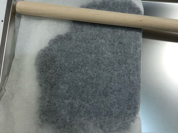 趁熱方便塑形時，將黑芝麻放入模具
上下可用烘培紙隔離避免沾黏
使用桿麵棍壓平（也可以用手壓平，要多墊一塊布避免燙到