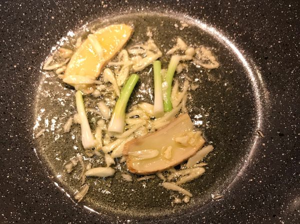 鍋燒熱放油，炒香蒜片、蔥白和薑片；