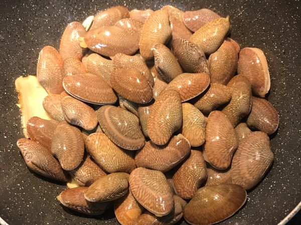 放入海瓜子，倒入米酒拌炒；