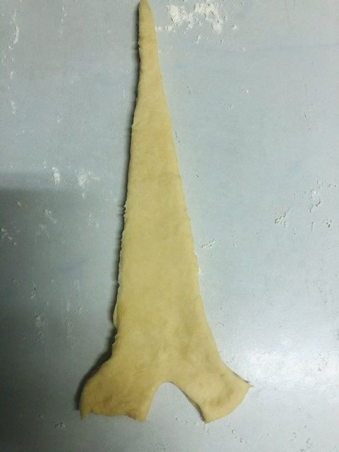 雙手由兩底邊往尖端捲起，雙手邊的尖角往內。以濕潤的布室溫或放入發酵箱發酵約45-60分鐘。在發酵時間剩10-12分鐘時，烤箱預熱170度攝氏。