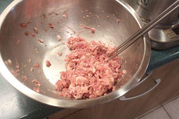 先做餃子餡，絞肉加入鹽、胡椒、酒、五香粉、七味粉，順時鐘拌出黏性。