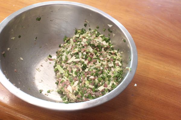再加入高麗菜、韭菜，再添一些調味，加入香油，拌勻後放入冰箱冷藏靜置30分鐘。餃子餡各家作法不同，可依個人喜好製作。