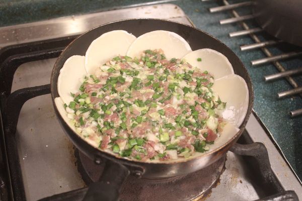 擺入一層餃子餡，鋪平。