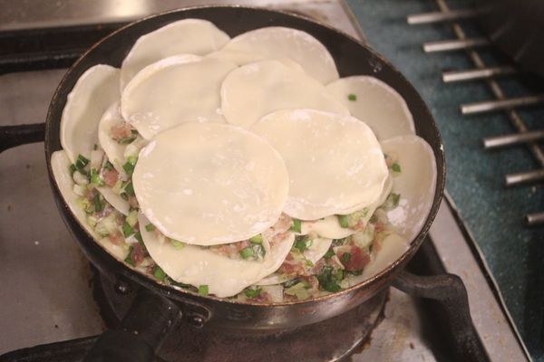 再擺一層餃子餡，再鋪上四張水餃皮，再重複一次，共有三層。