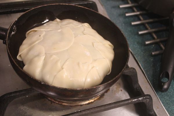 將鍋底的水餃皮抹一些水包上來。