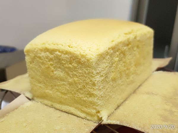 蛋糕出爐後，不必倒扣喔！
連同烘烤紙將蛋糕拉出吐司模
立即撕開四面的烘烤紙散熱
放到微溫，可包起來放到冰箱冷藏
冰一個晚上後
蛋糕口感會更加美味喔