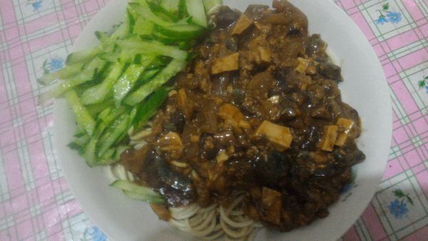 油麵燙過擺盤，淋皮蛋炸醬，放上小黄瓜絲完成