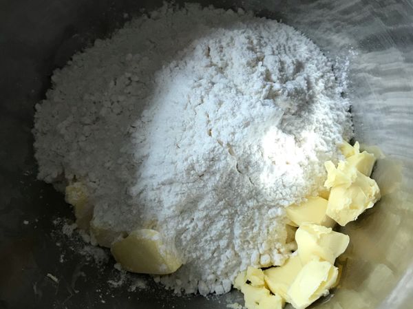 把麵粉跟切成小塊的奶油，加在一起，我是帶了手套把他捏成了沙粒狀～然後加雞蛋 糖 一點點鹽巴，混合成麵團～