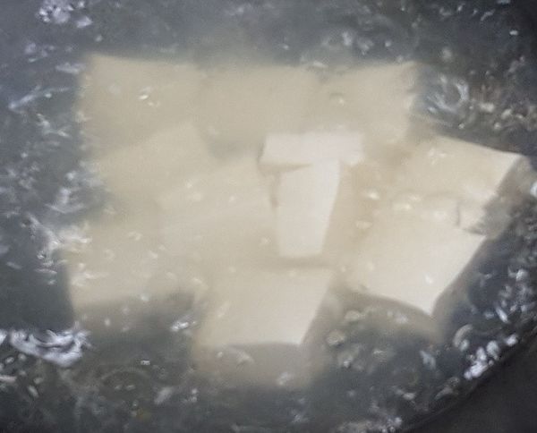 將豆腐先放入滾水中川燙一下即可撈起瀝乾水分