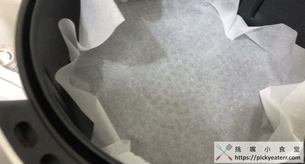 氣炸鍋中鋪上烘焙紙，並將板豆腐放入氣炸鍋中，溫度設定180度、時間10分鐘。