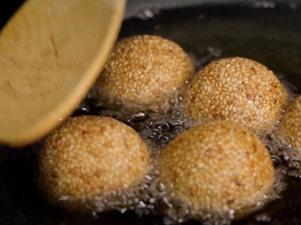 在炸的同時，如果想要芝麻球保持圓形型狀，
可以用木匙，在炸的同時塑型。